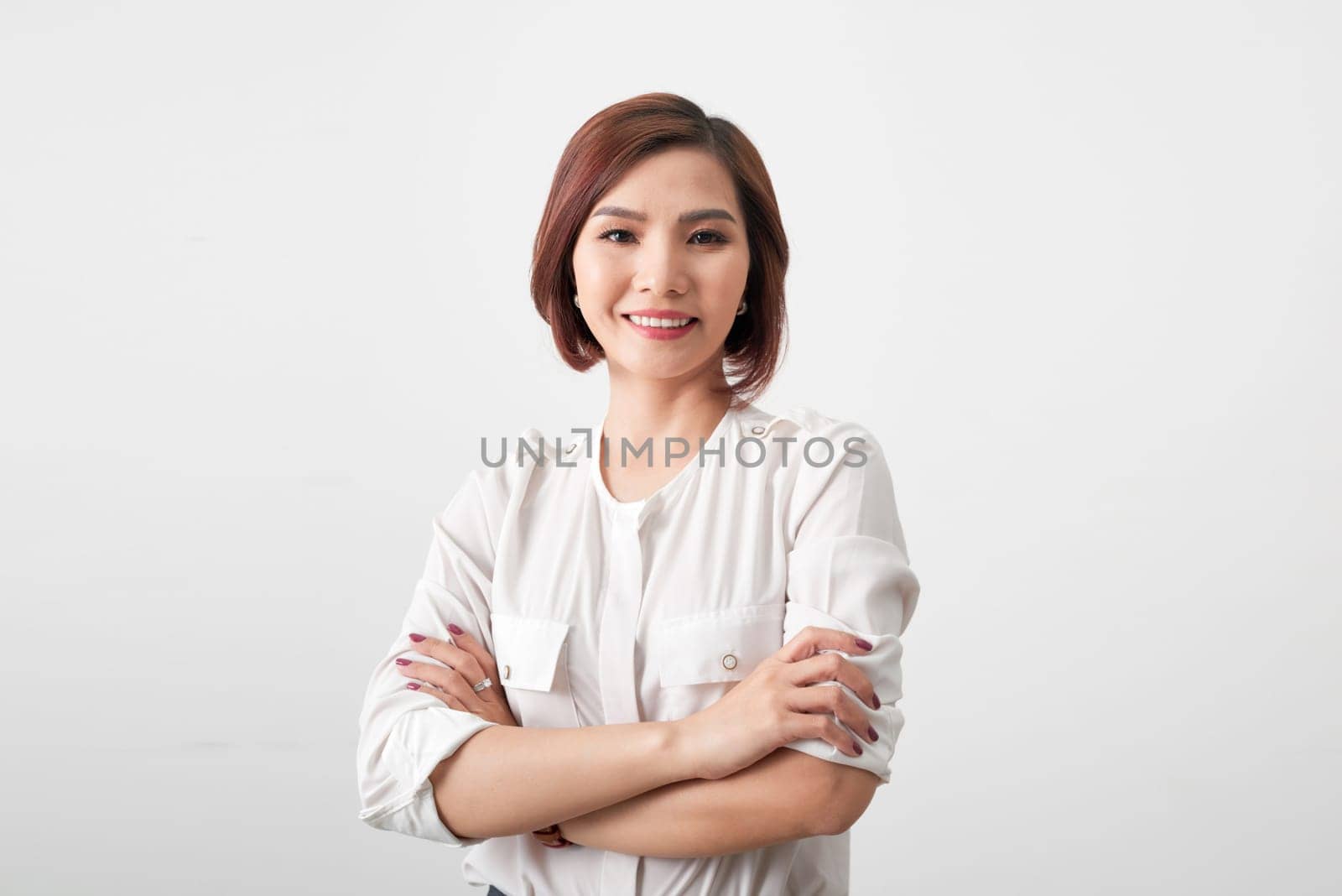 Asian successful confident young businesswoman with arms crossed isolated in white background