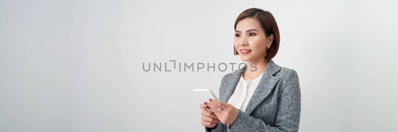 Attractive beautiful Asian businesswoman using and typing smartphone isolated on white banner by makidotvn