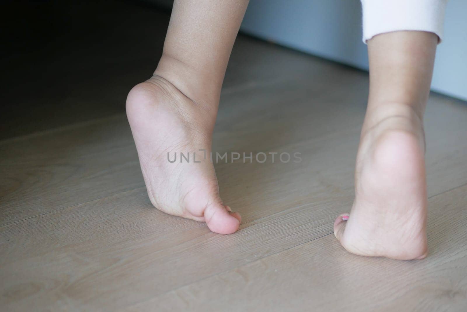 low angle view of A child walking on tiptoes.