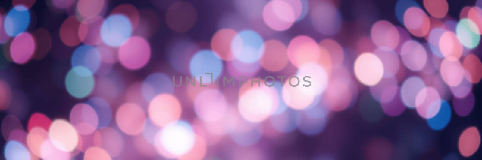A vibrant display of blurred lights illuminates the space, creating a joyful mood during evening festivities at a community gathering.