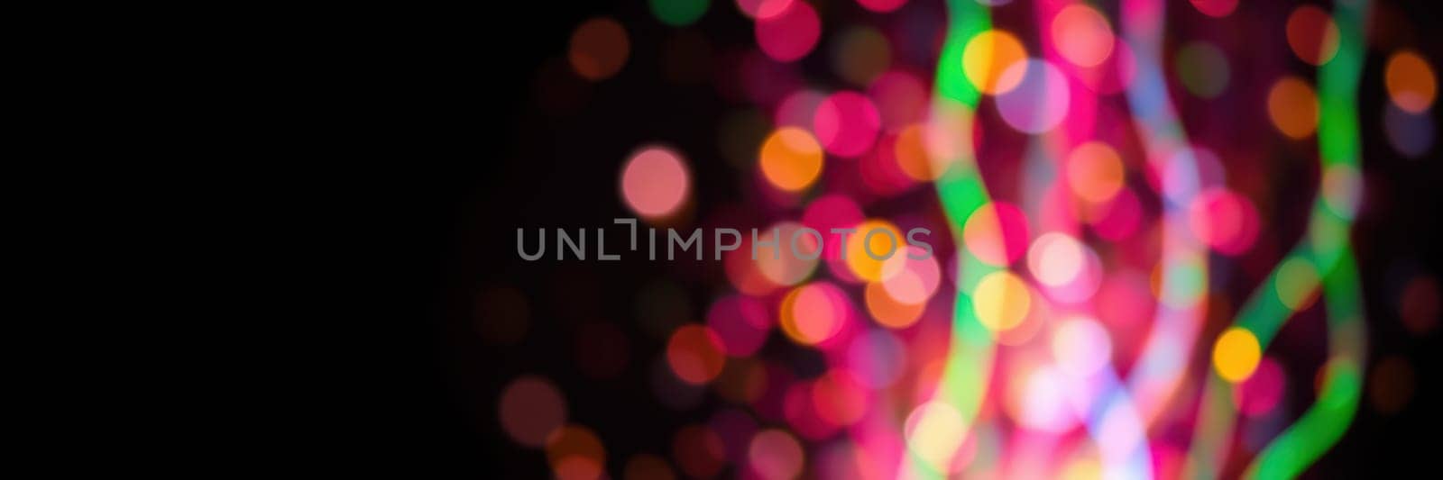 A vibrant array of colorful lights illuminates the night, creating a joyful ambiance. People enjoy the spectacle, enhancing the festive mood in the park during the celebratory event.
