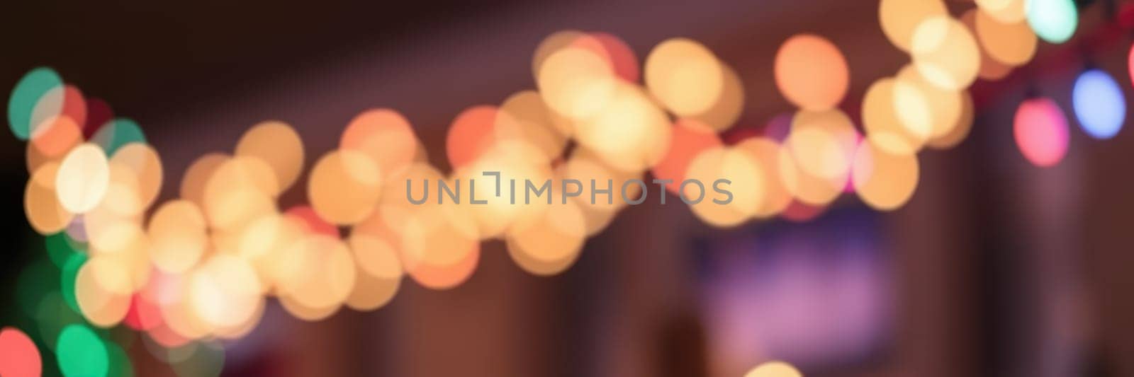 Bright, colorful lights create a warm and inviting ambiance in a cozy space filled with holiday cheer, enhancing the festive mood for everyone gathered.