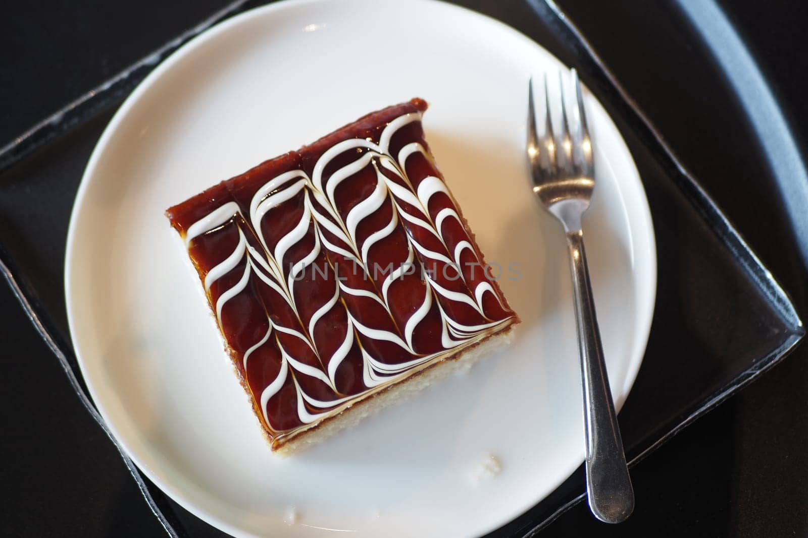This dessert showcases intricate frosting work on a beautifully presented cake slice