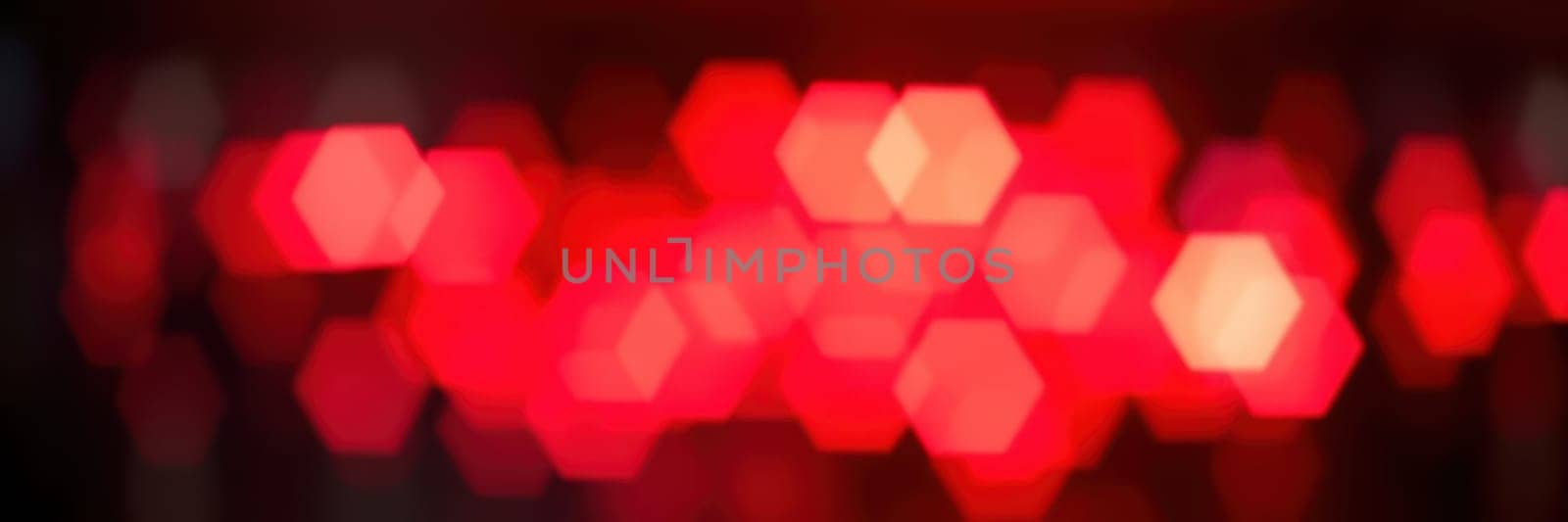 A series of bright red lights illuminate a dark space, creating a dynamic and energetic ambiance for an evening event. The vibrant glow enhances the excitement and mood.
