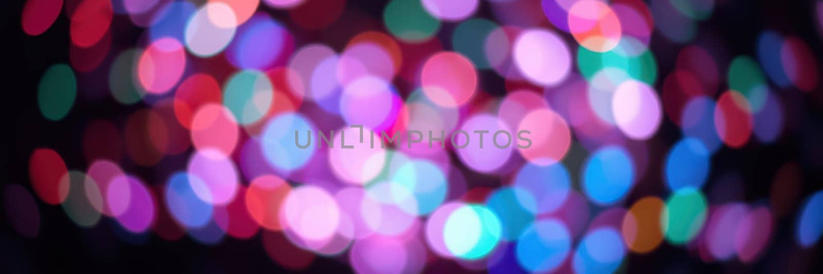 Bright bokeh lights in shades of pink, blue, and green illuminate the area, adding a joyous touch to the evening celebration with a vibrant ambiance.