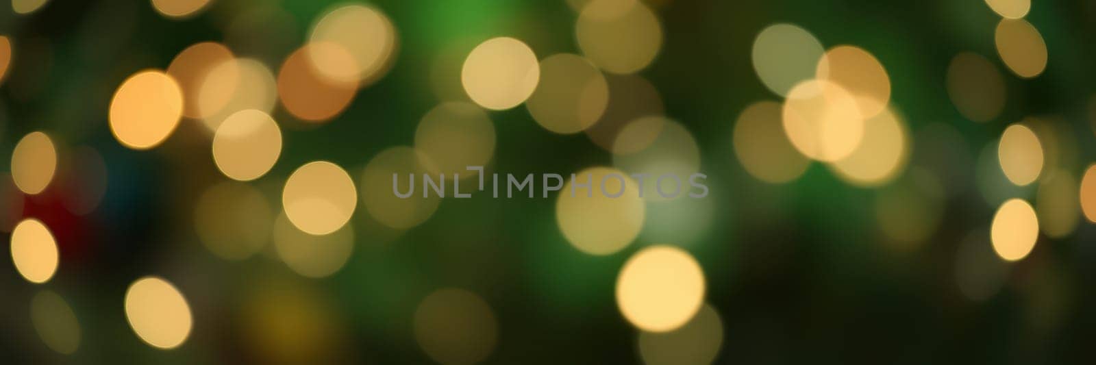 Bright, circular lights out of focus create a magical atmosphere, perfect for holiday celebrations. The vibrant colors enhance the festive mood and joy of the season.