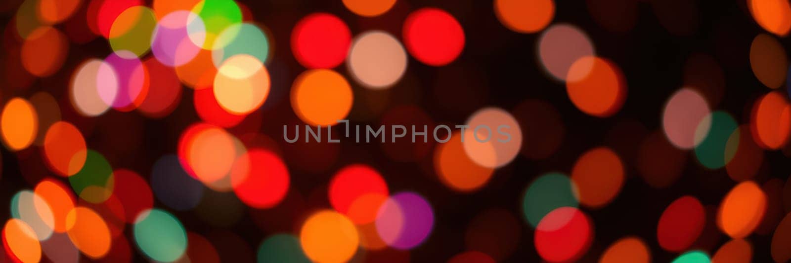 Bright and colorful lights blur into vibrant circles, filling the night with a warm and joyful ambiance. The scene evokes a sense of celebration and holiday spirit in the city.