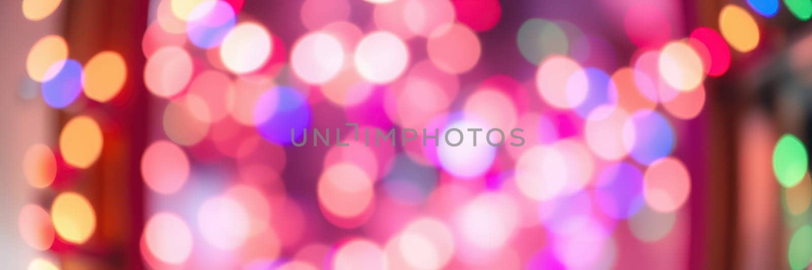Shimmering bokeh lights fill the background with cheerful colors, enhancing the festive atmosphere of an indoor space during the holiday season, inviting joy and celebration.