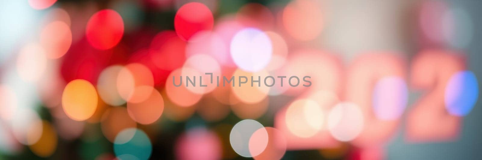 Bright and colorful bokeh lights create a joyful atmosphere for New Year celebrations, highlighting the transition to 2022 in a festive indoor setting.