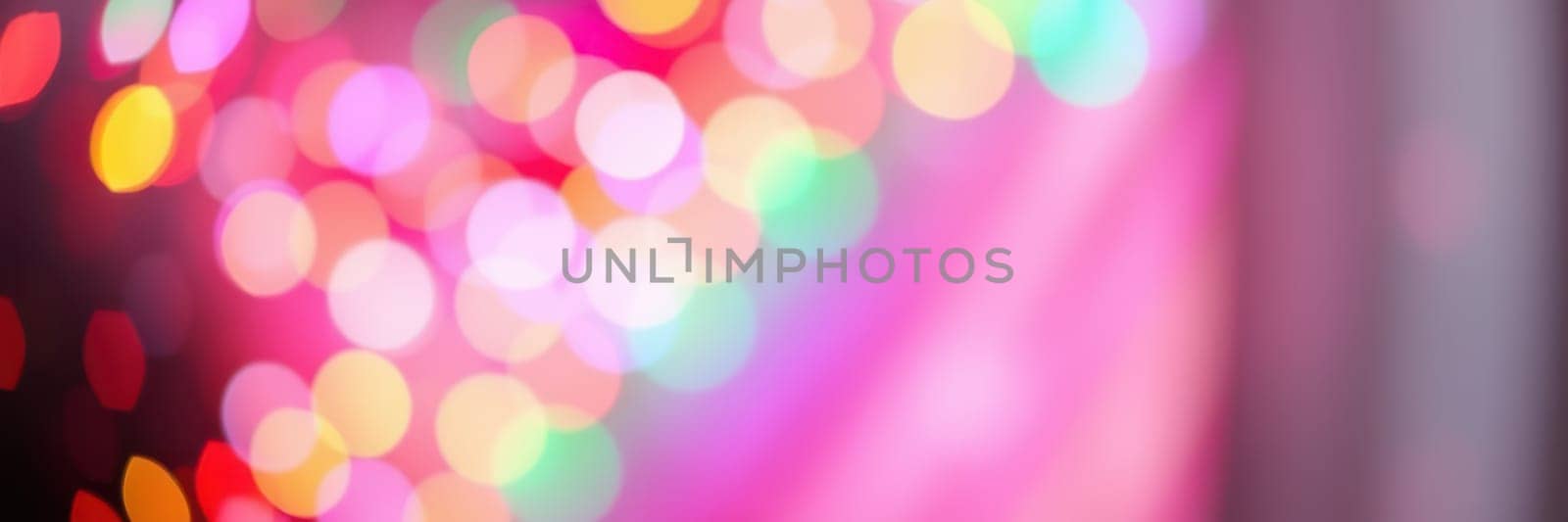 Vibrant bokeh lights in various colors create a festive mood during a nighttime event, enhancing the joyous ambiance for attendees to enjoy.