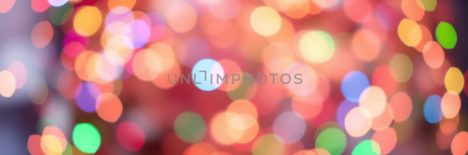 Vibrant bokeh lights in various colors fill the background, enhancing the joyful ambiance of a festive gathering during the holiday season at an event venue.