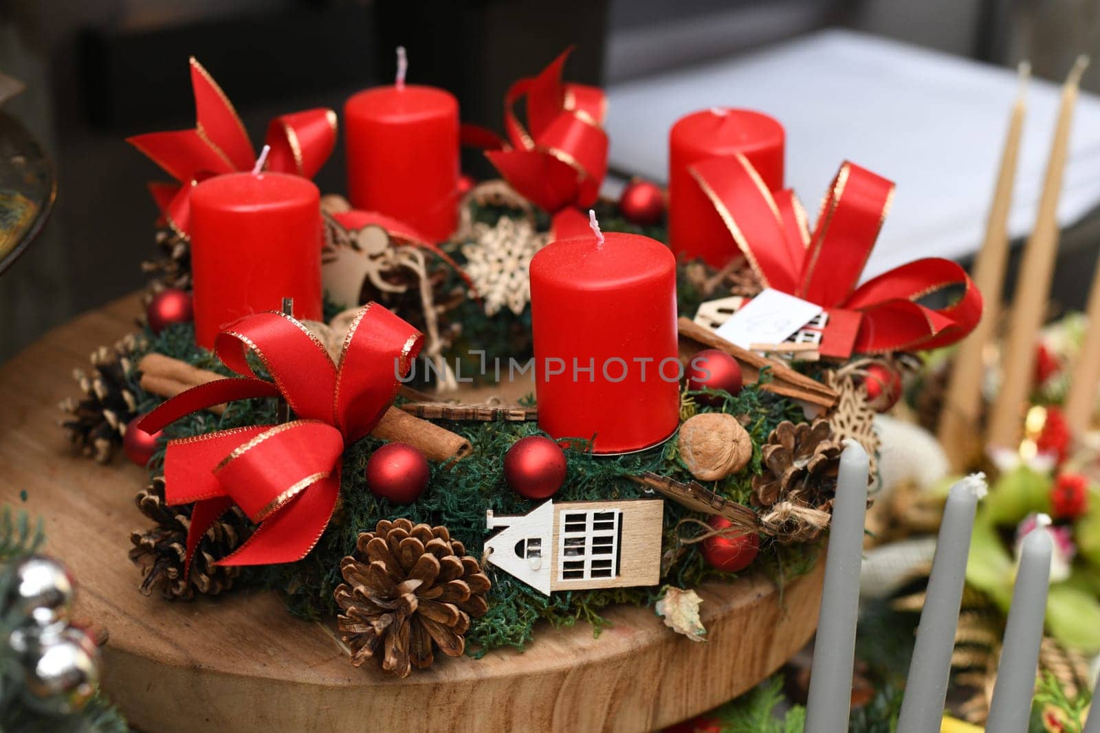 Wreath with red candle decorated with red balls, pine cones, cinnamon,walnuts.