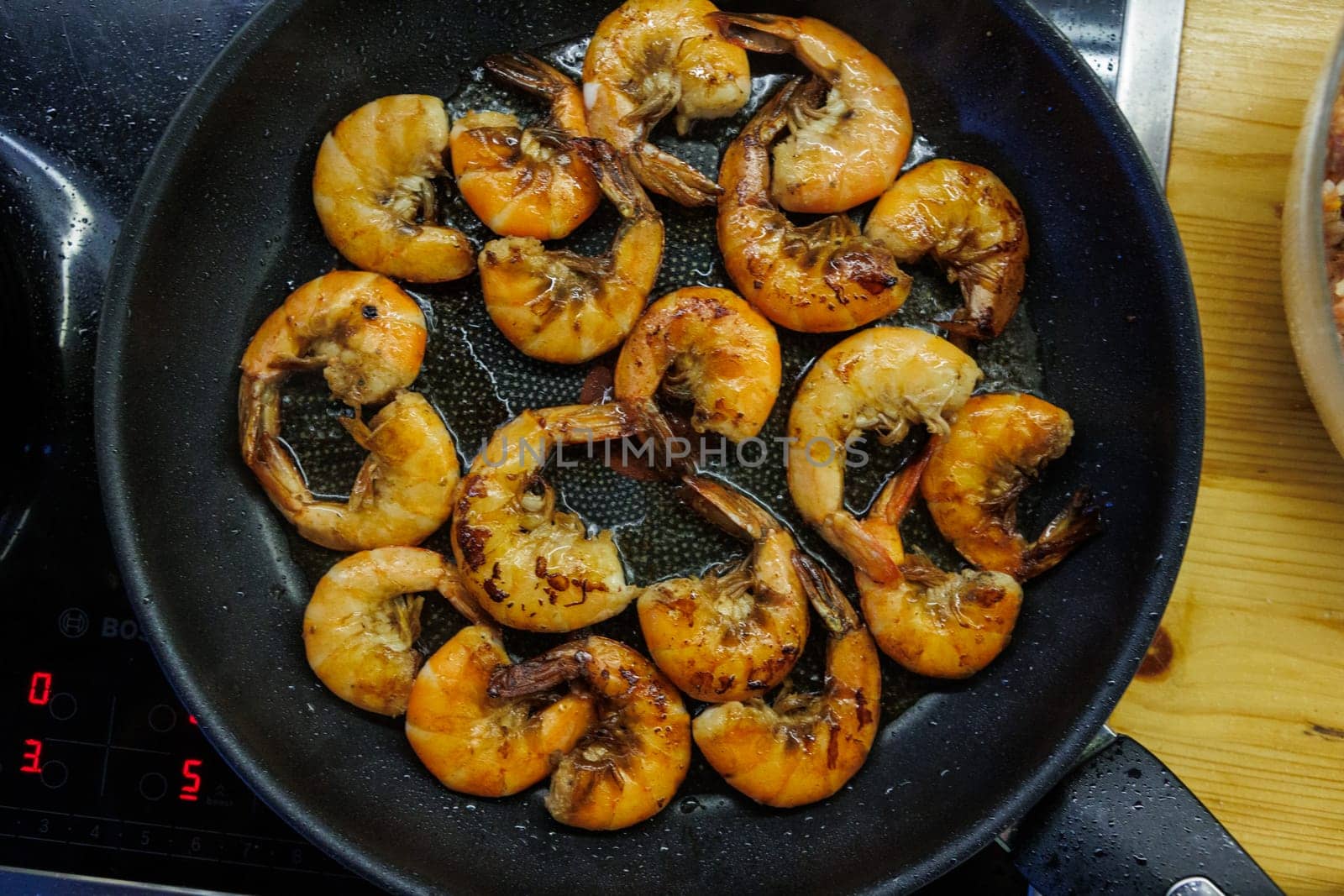 Golden pan-fried shrimp sizzling in a skillet, showcasing their rich, juicy texture and vibrant color. Ideal for use in cookbooks, restaurant menus, or gourmet advertisements