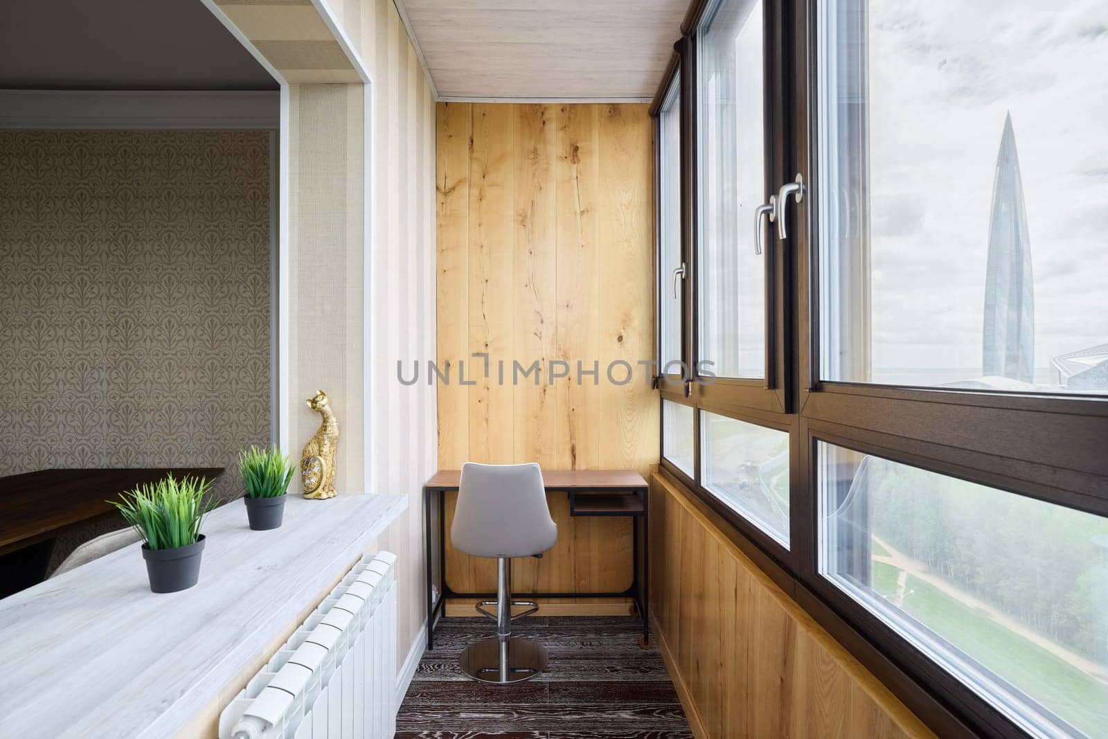 This is a stylish home office that features abundant natural light, minimalist design, and lovely wooden accents