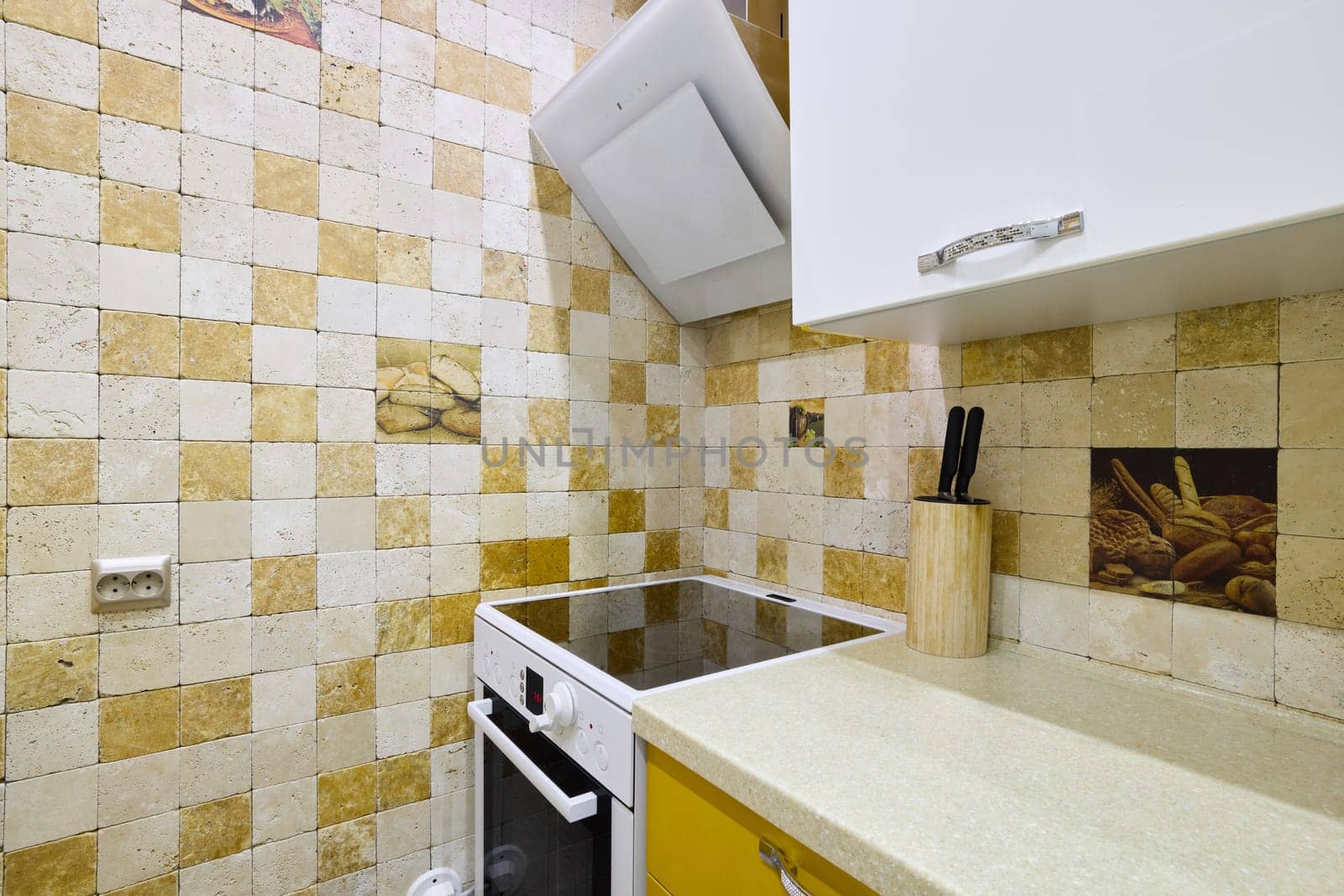 This charming kitchen boasts elegant tiles and modern cooking appliances, creating a delightful cooking space