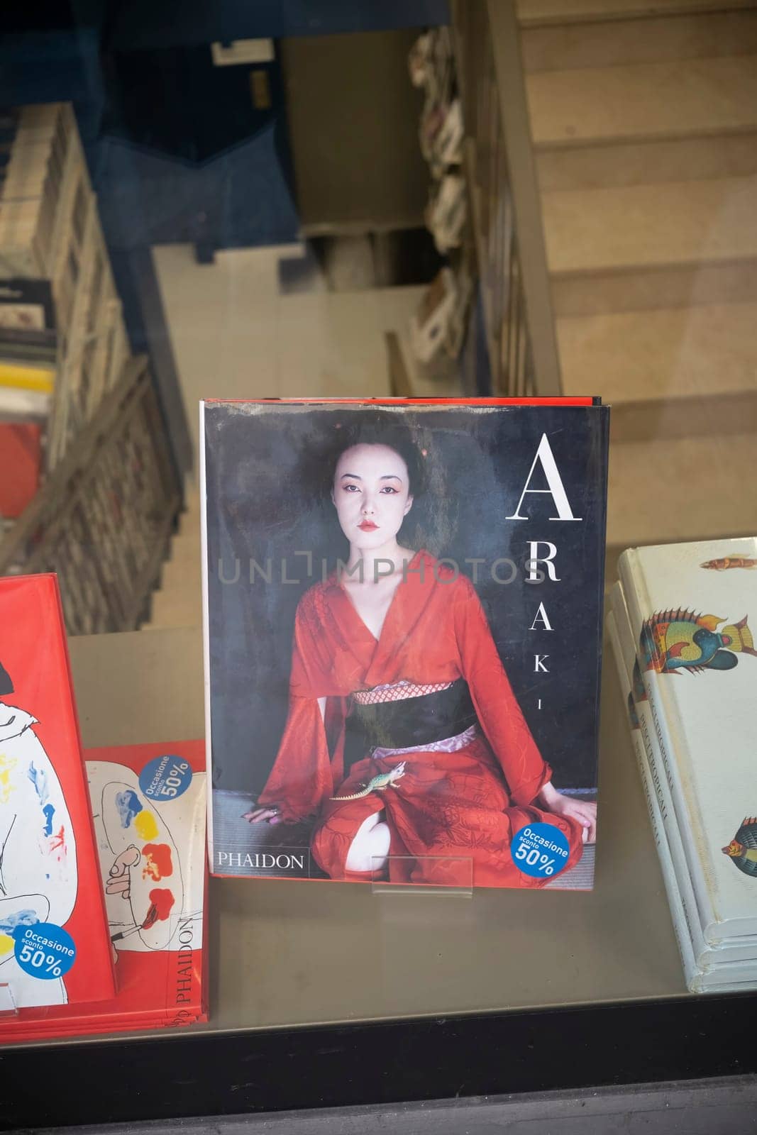 Cremona, Italy - November 27th 2024 A photography book by nobuyoshi araki, featuring a geisha, sits in a bookstore window display in cremona, italy