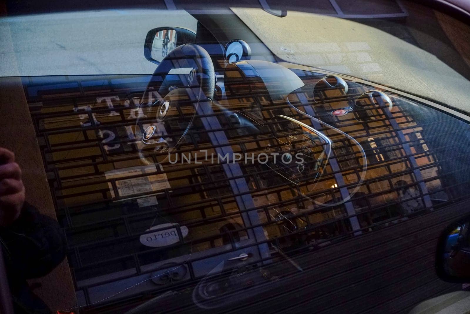 Cremona, Itally - October 6th 2024 View of a smart fortwo car's interior, with a reflection of a closed storefront in the windshield