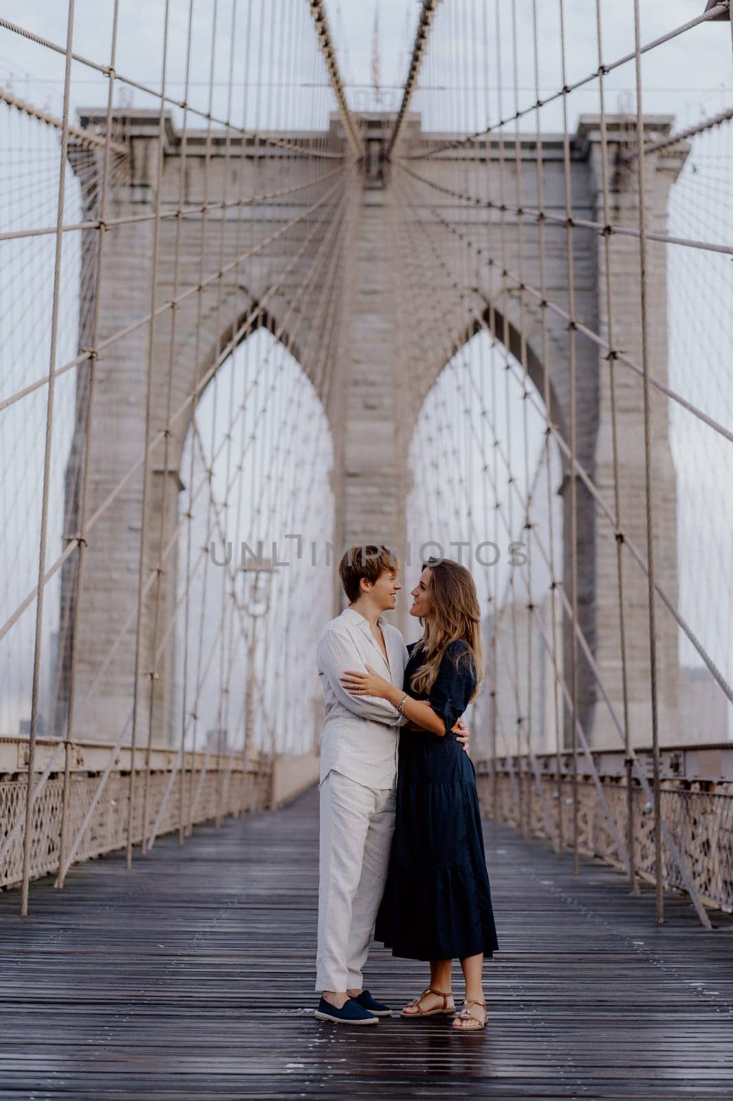 A loving couple shares a romantic moment on the iconic Brooklyn Bridge, capturing their extraordinary bond