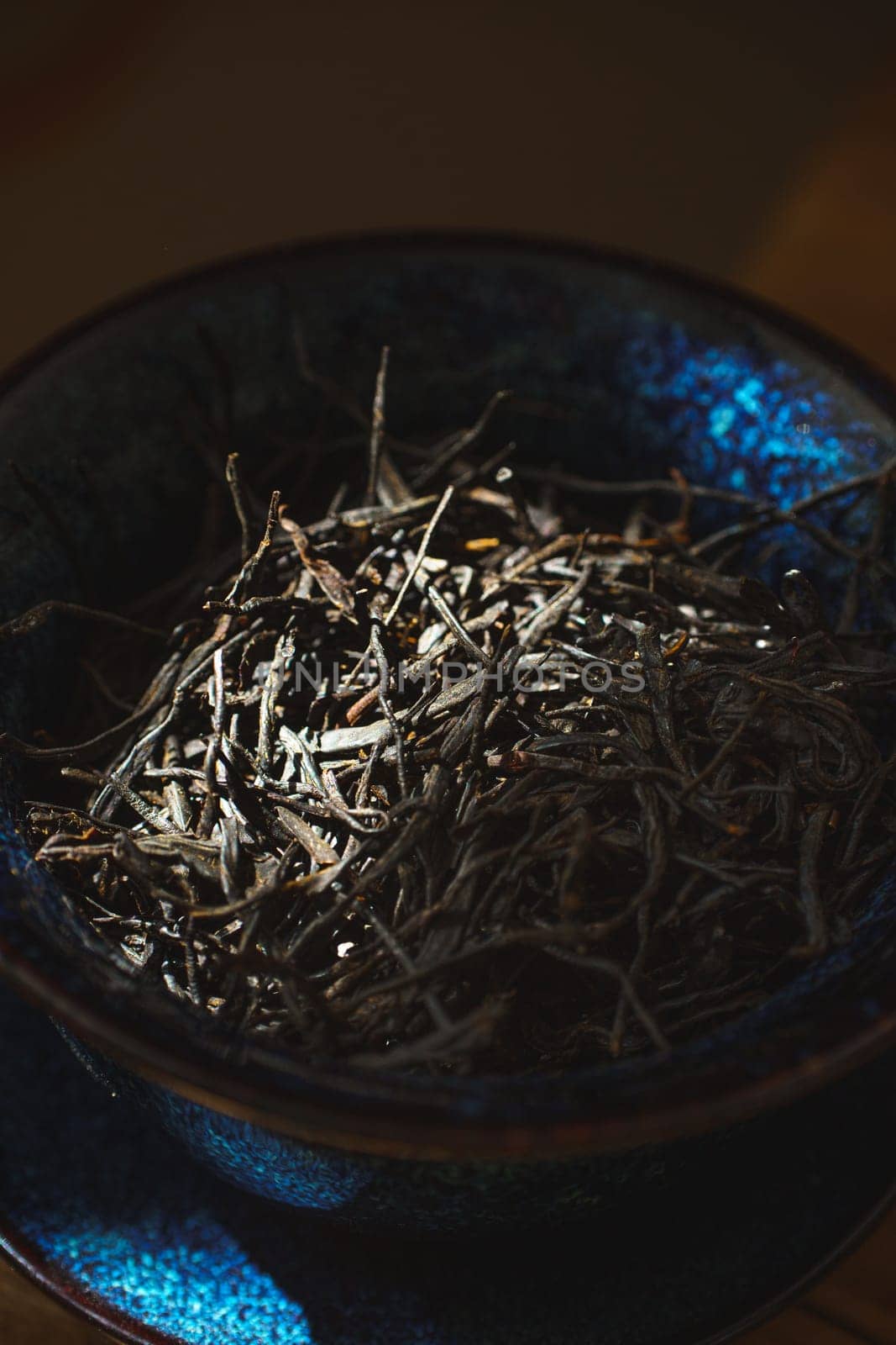 Closeup of dried twigs in a charming blue bowl, highlighting intricate textures and earthy elegance