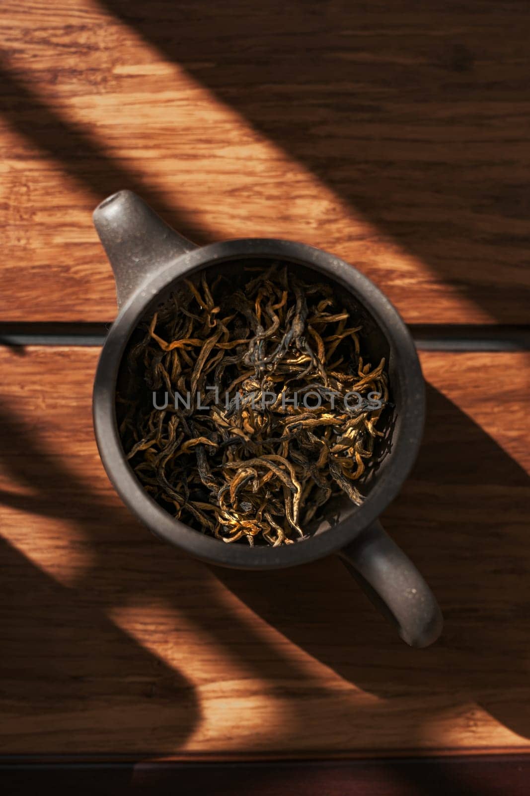 Dried tea leaves in a rustic pot capture natures essence and enhance our overall wellness experience