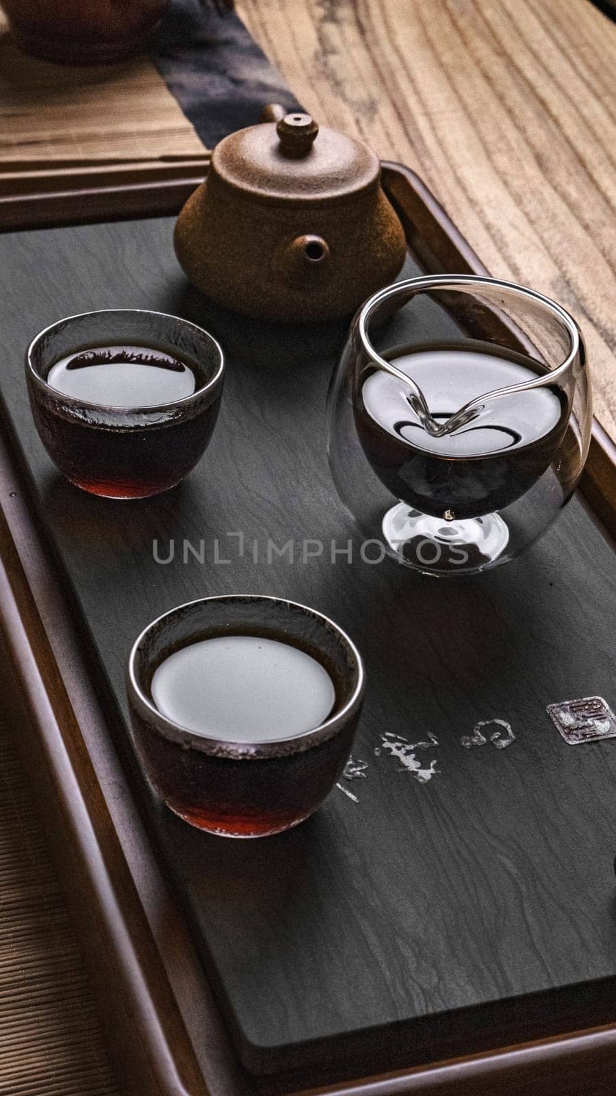 There is a stunning and beautifully arranged display of tea presented in traditional glassware on a wooden tray