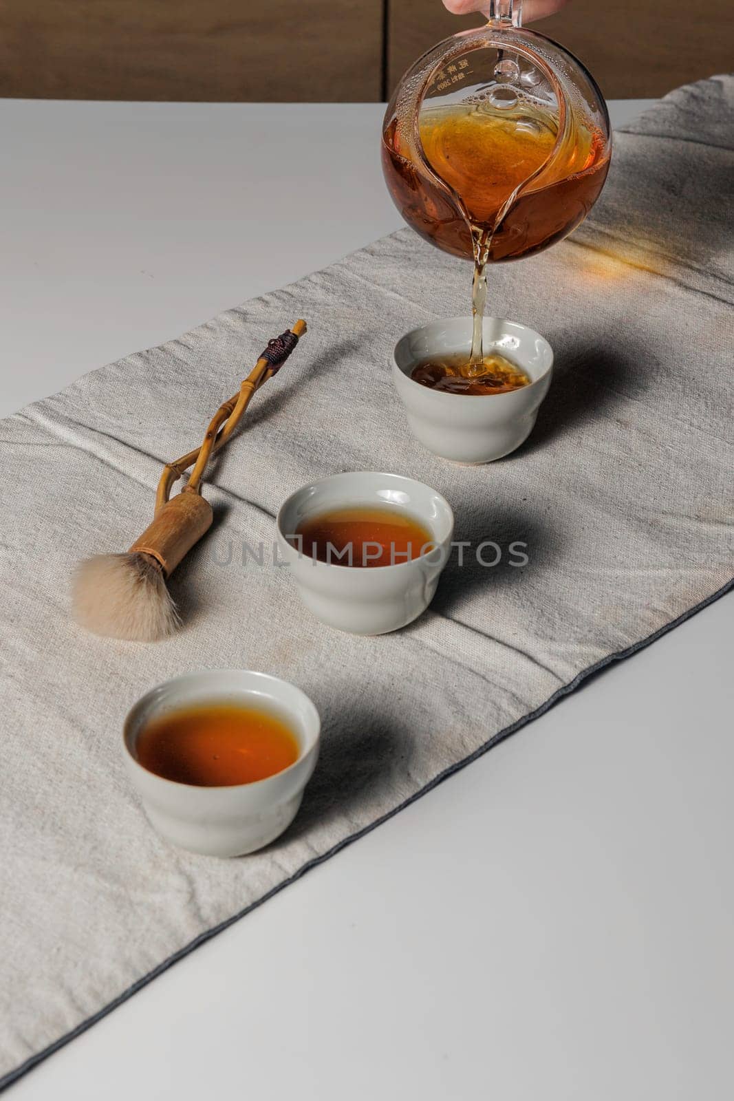 A serene and tranquil tea ceremony beautifully showcasing the art of pouring tea into elegant, delicate cups