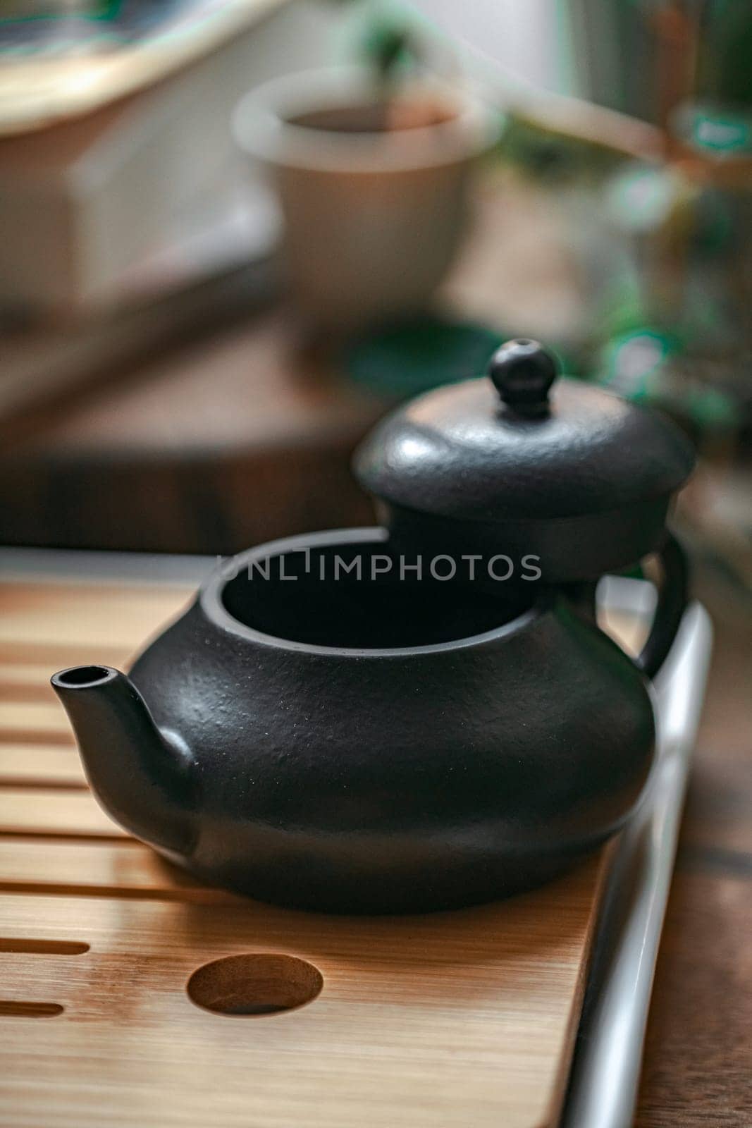 A beautifully crafted black teapot, elegantly poised on a wooden tray, ideal for passionate tea enthusiasts everywhere