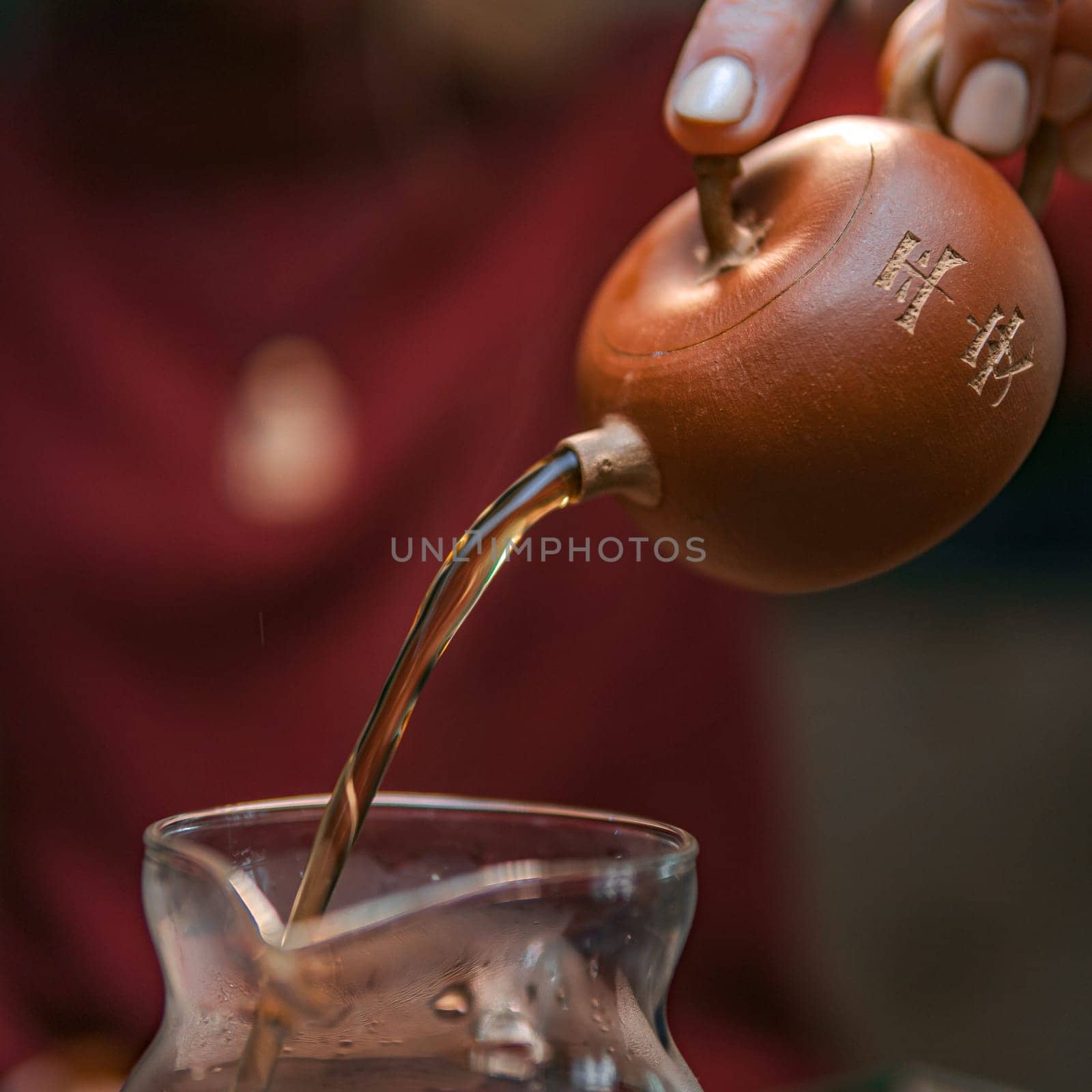 A serene and peaceful moment is beautifully captured as herbal tea is poured smoothly from a gourd into a lovely glass