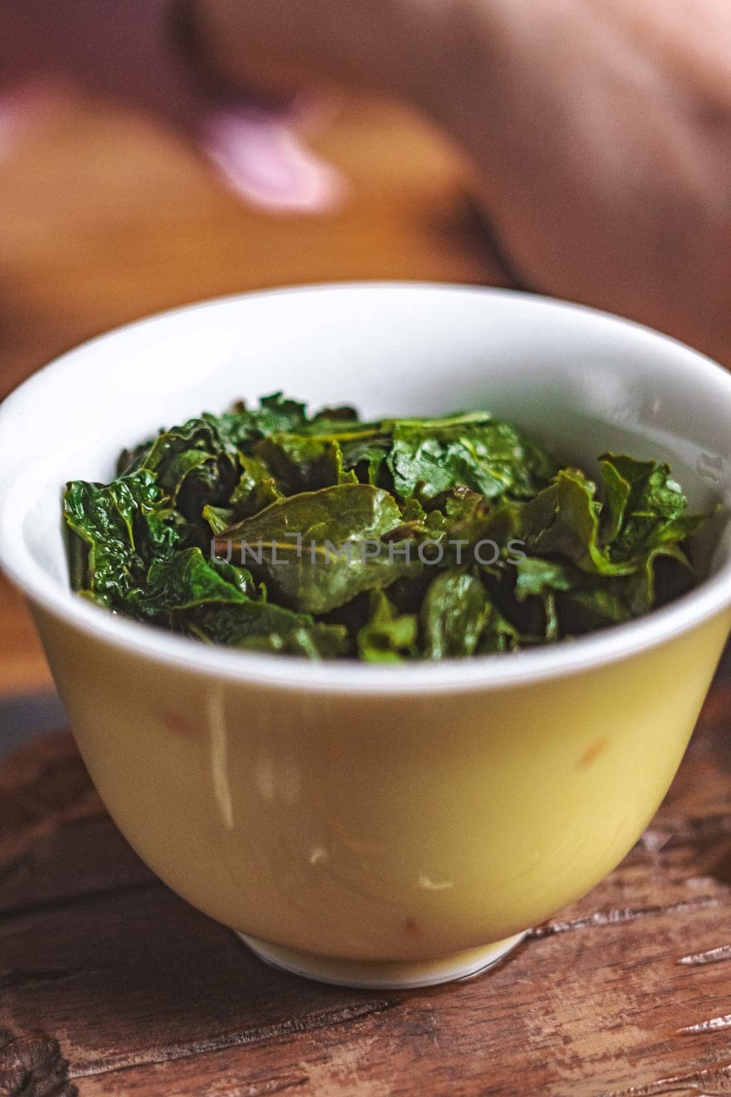 A vibrant, colorful bowl filled with fresh, crispy green kale leaves, which is perfect for a variety of healthy dishes