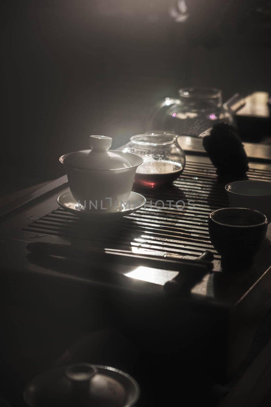 A serene tea setup with delicate teapots and exquisite cups, beautifully arranged and gently illuminated