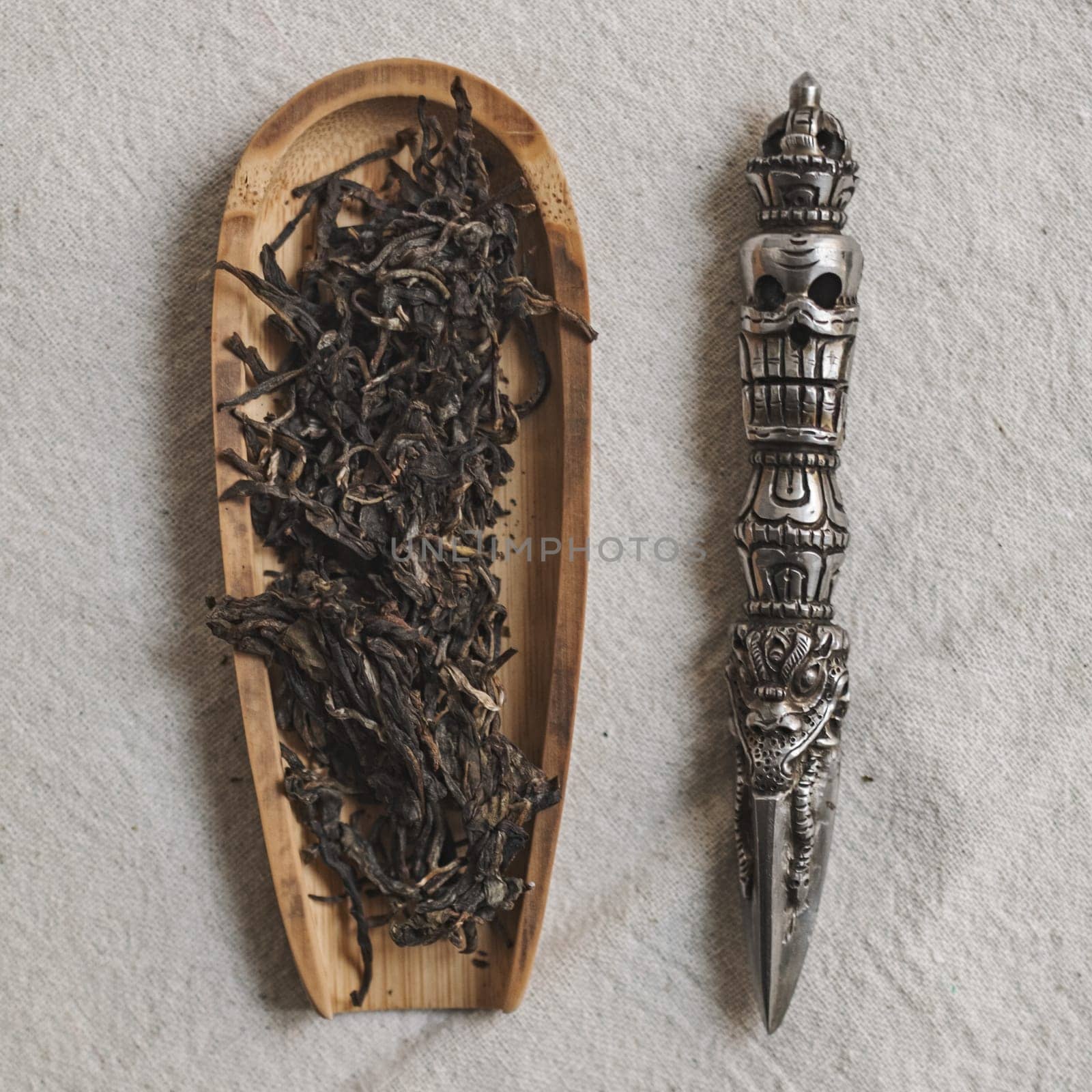 An artistic and creative arrangement of dried tea leaves along with a decorative tool designed for tea preparation