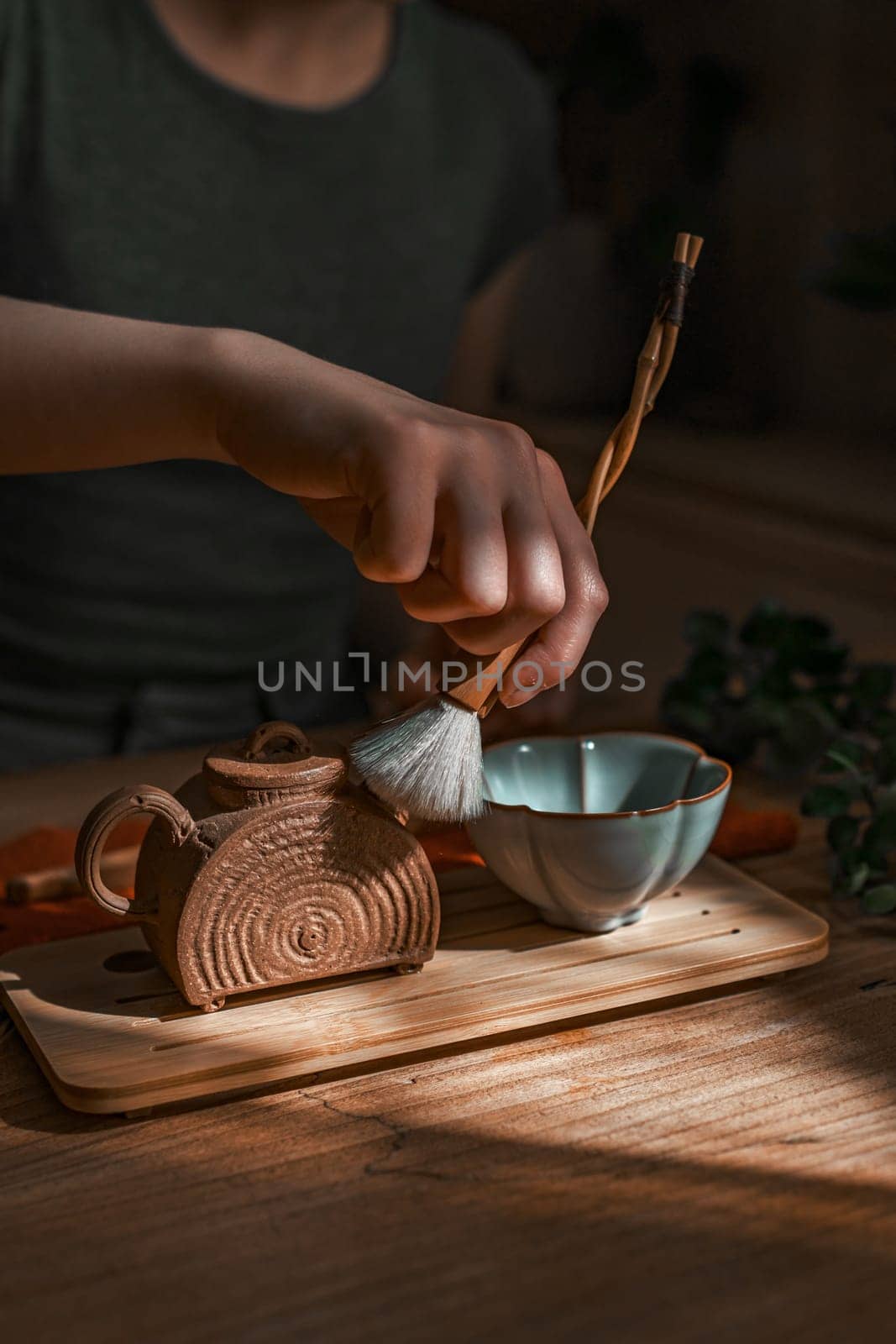 A serene moment of meticulously preparing tea, showcasing fine craftsmanship along with natural materials