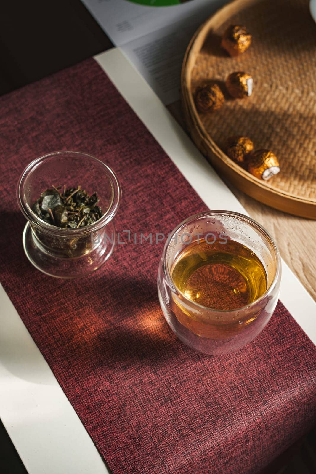 A serene and tranquil setting that beautifully features aromatic herbal tea, elegant glassware, and delightful treats