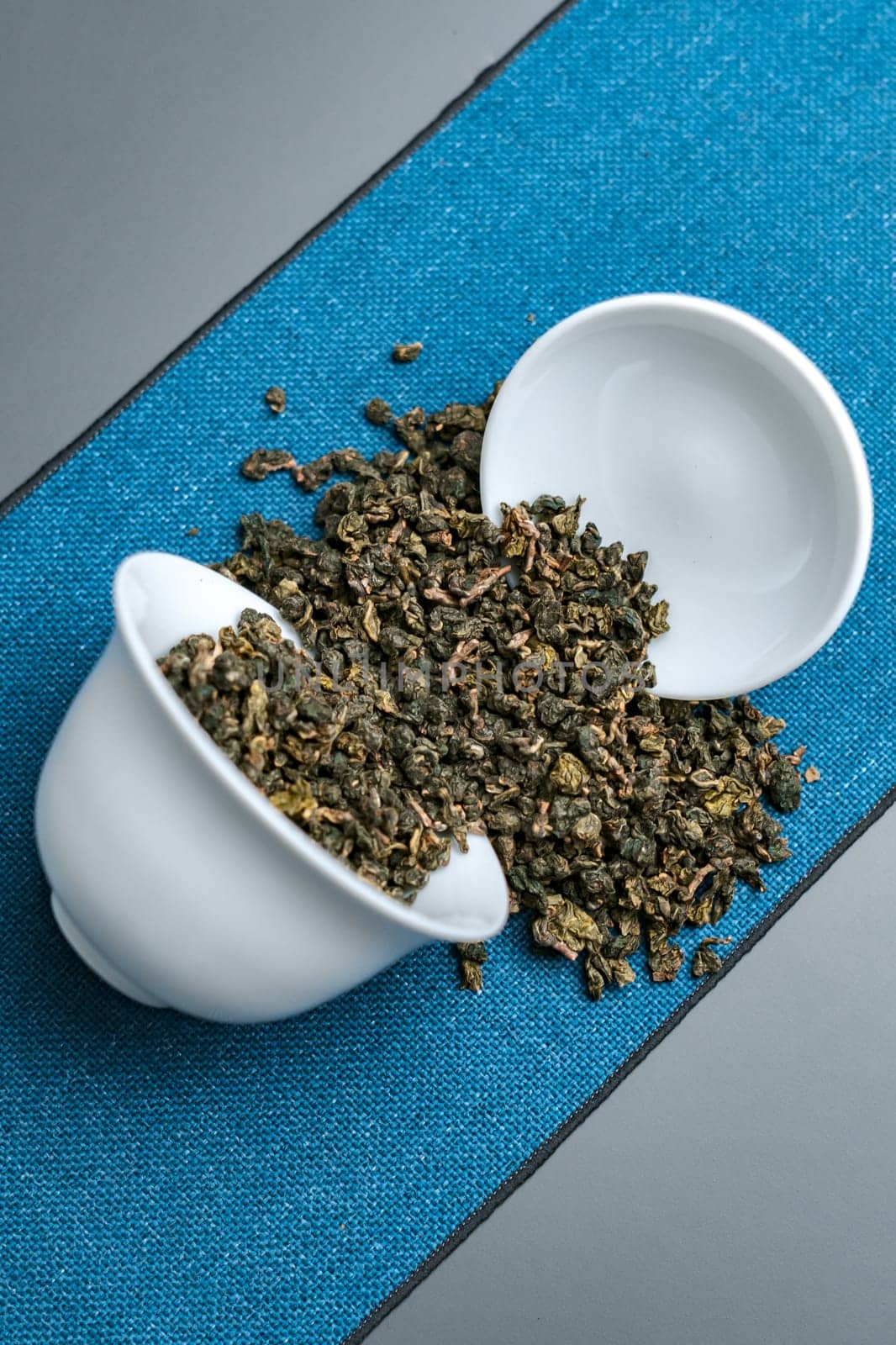 An aesthetically pleasing view showcasing loose leaf green tea gracefully spilling from an elegant bowl