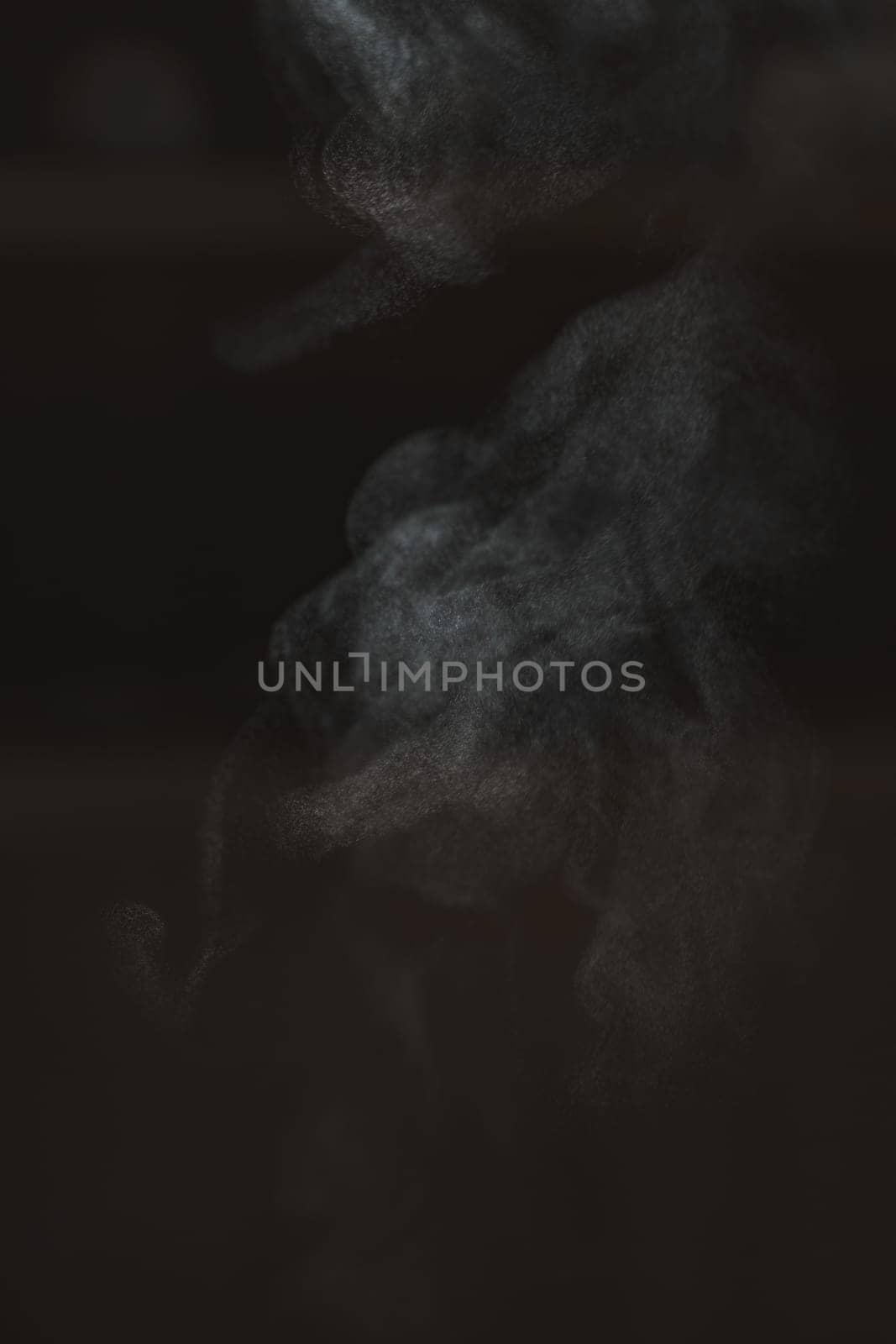An abstract image showcases ethereal smoke patterns gracefully flowing against a dark and mysterious backdrop