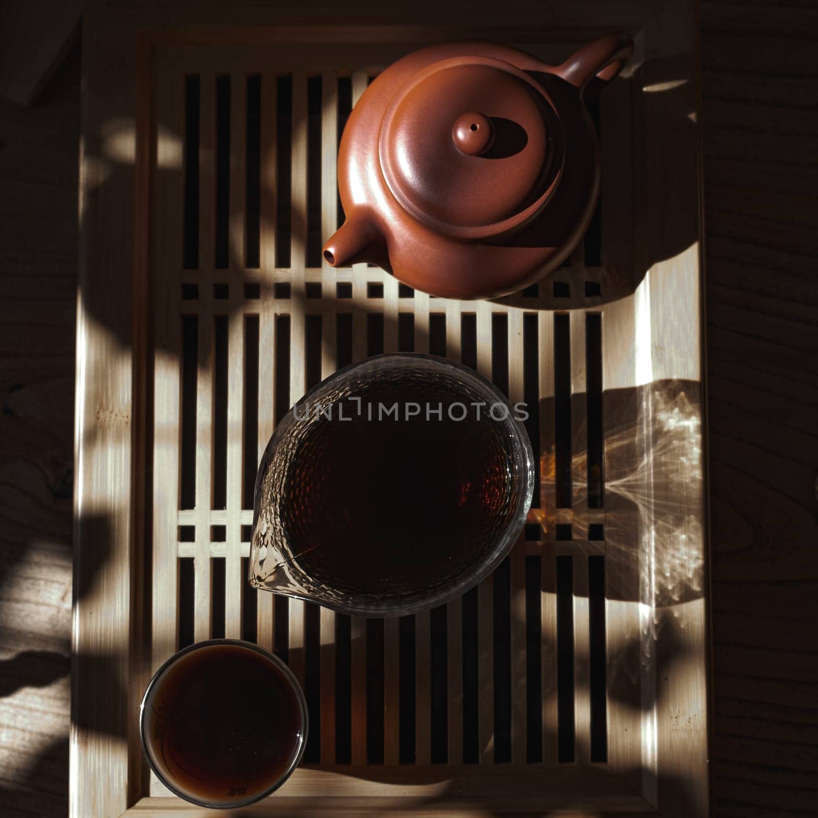 A serene tea setup with a fine pot, elegant pitcher, and cozy cup of tea, all in soft, warm sunlight
