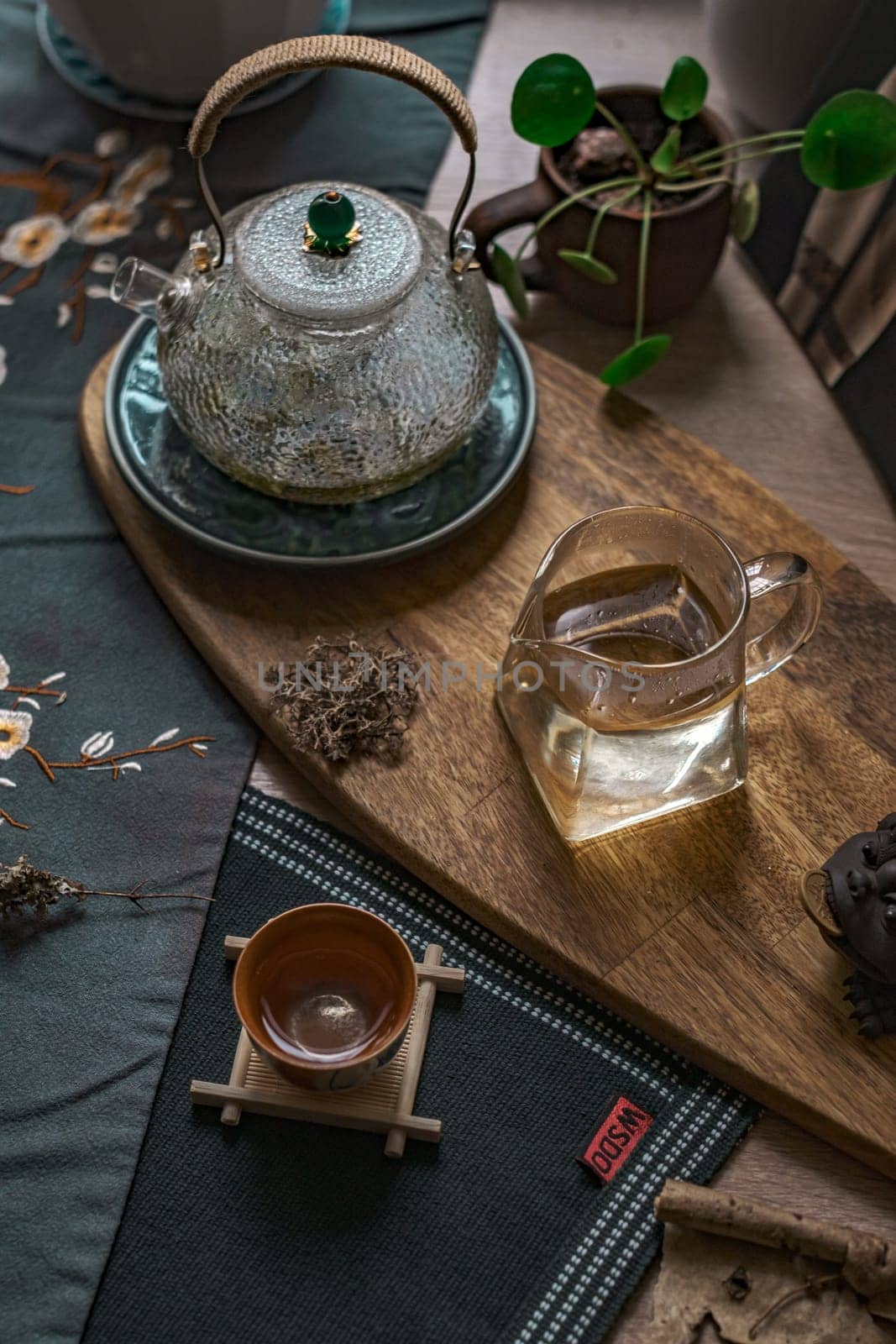 A beautiful tea experience with a stunning glass kettle, elegant wooden tray, and essential tea accessories