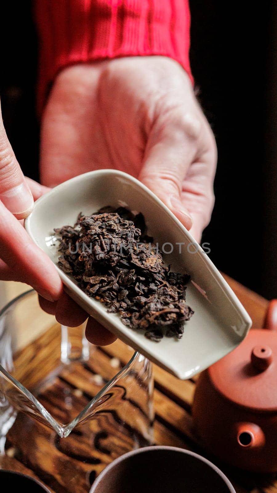 This is a closeup view of loose leaf tea elegantly arranged and presented in a traditional ceramic dish