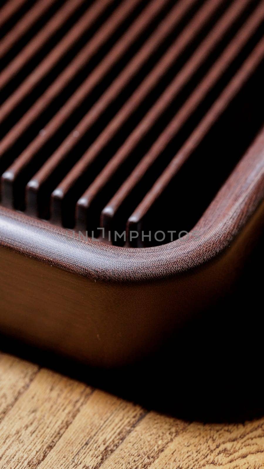Closeup view of a stylish wooden serving board showcasing deep grooves, perfect for food presentation