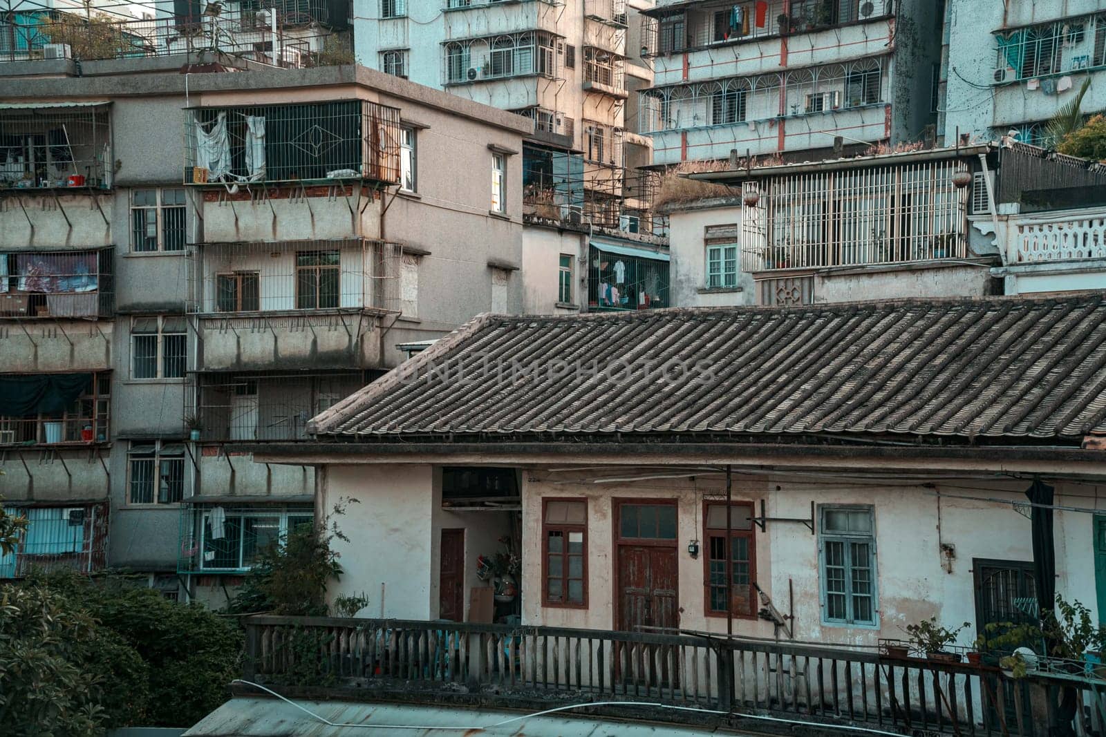 A striking juxtaposition of an old house surrounded by contemporary highrises in a bustling urban environment