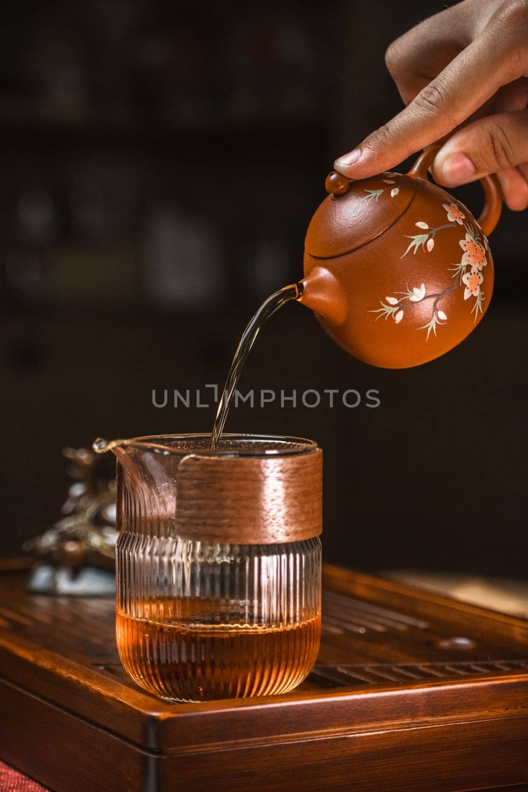 A tranquil and serene moment beautifully captures the elegant art of pouring tea from a lovely teapot