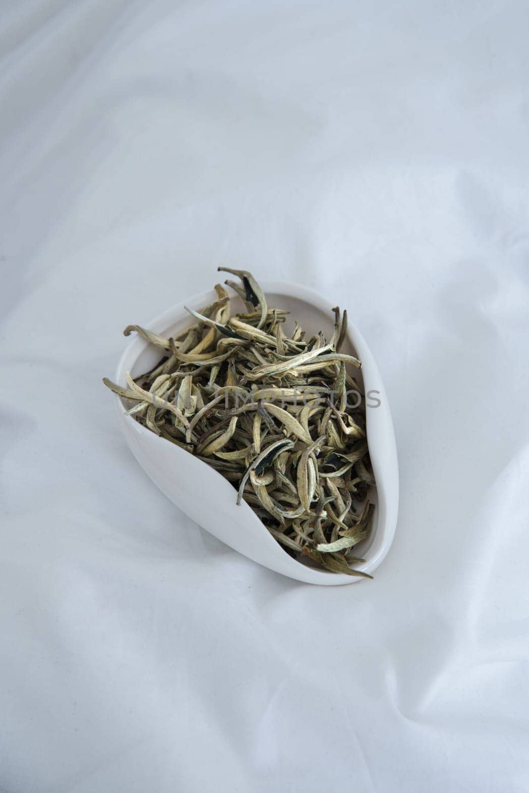 A vibrant closeup image showcases dried small fish artfully displayed in a sleek, modern white serving dish