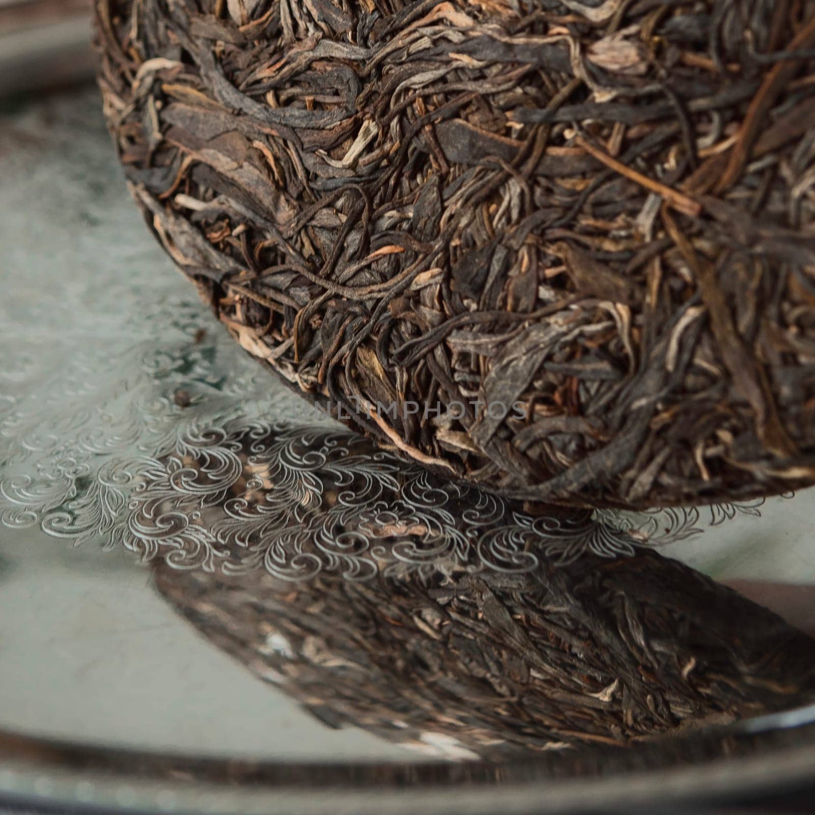 An artistic depiction of a compressed tea ball, showcasing its rich texture and alluring reflection