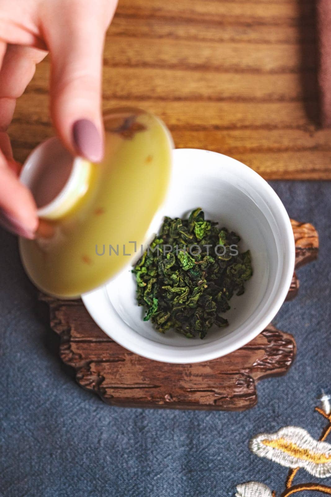 An elegantly curated setup for brewing exquisite green tea using loose leaves in a stunningly beautiful teacup