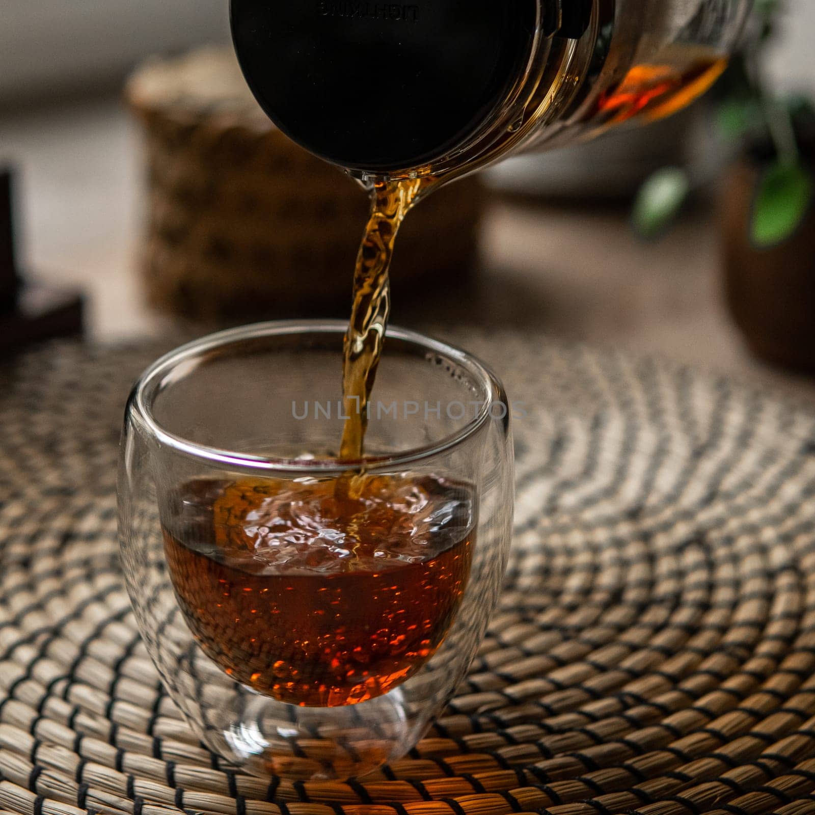 A refreshing and invigorating glass of iced tea is being poured, surrounded by a warm and inviting atmosphere