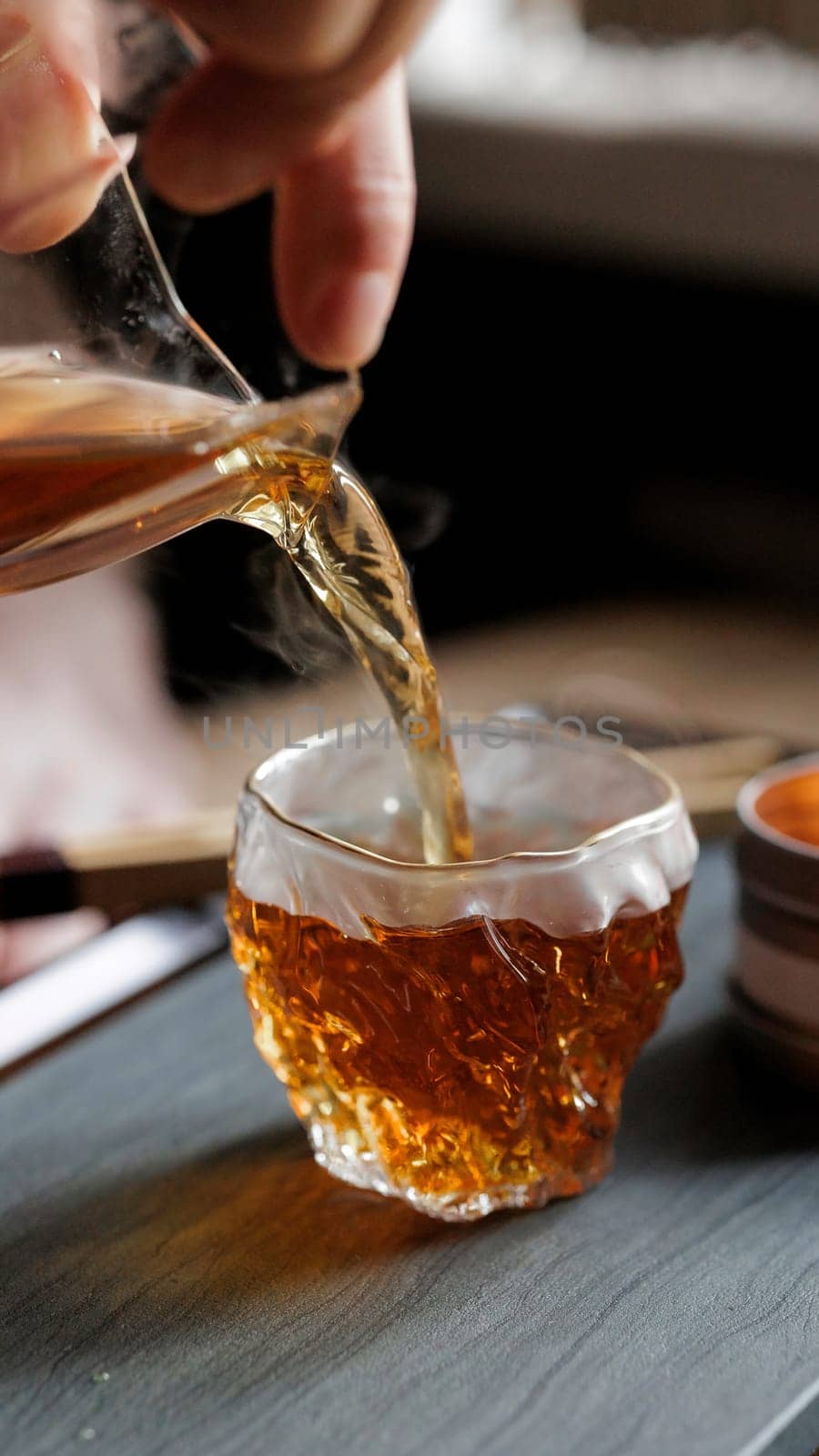 A close-up of a beverage being poured into a textured glass, showcasing rich colors and inviting foam.