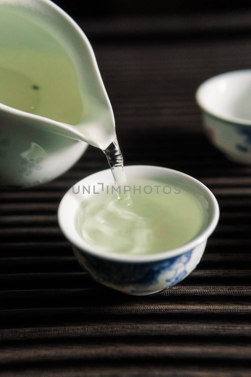 A serene moment unfolds as tea is poured into delicate porcelain cups, showcasing rich Chinese tea culture