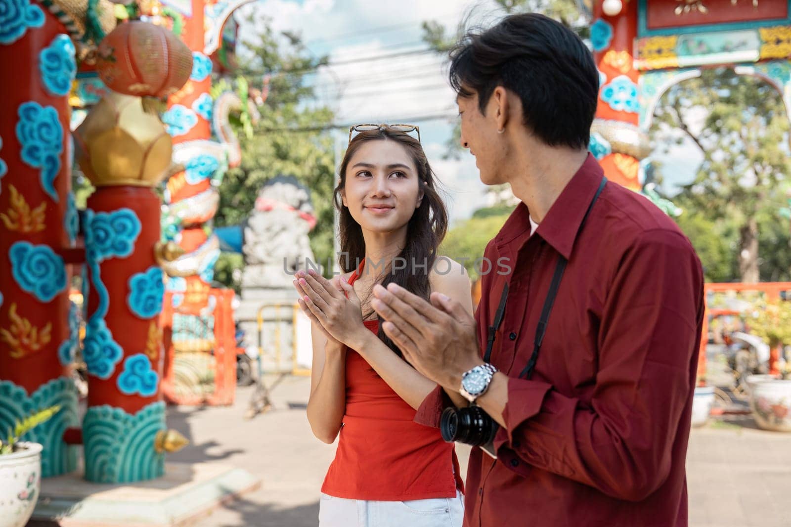 A couple cherishes the vibrant celebrations of Chinese New Year at a stunning temple embracing joy and tradition.