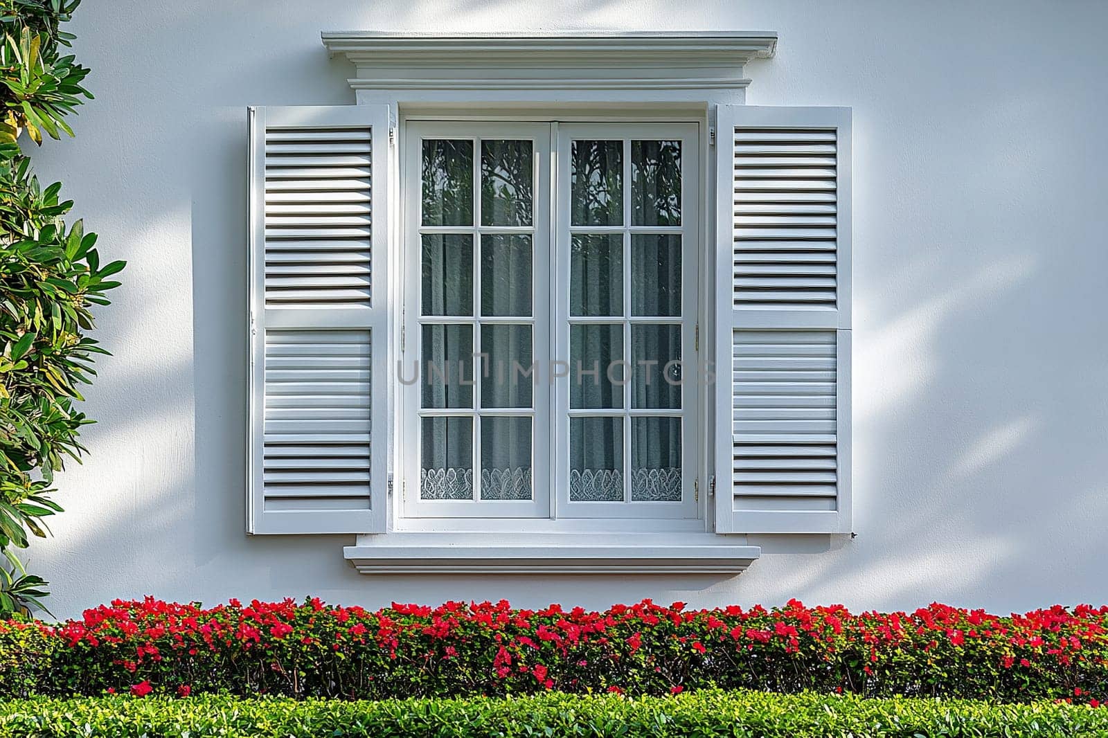 Window with white wood shutters on white building, front view