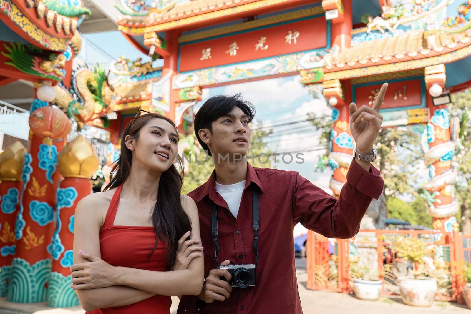 A couple enjoys vibrant festivities during the Chinese New Year exploring colorful decorations and traditions in the heart of the celebration.